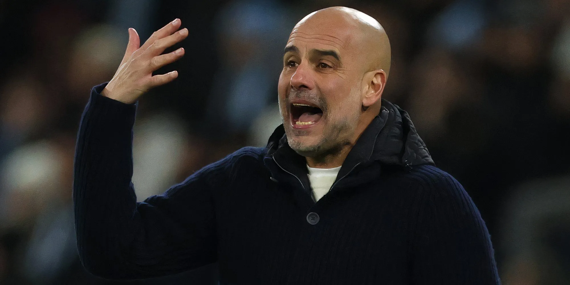 Huấn luyện viên Pep Guardiola của Manchester City đứng trên đường biên
