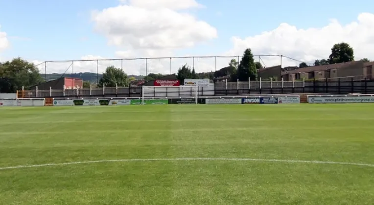 Góc khán đài The Bath End tại sân Twerton Park, một trong những khu vực dành cho cổ động viên nhà, với khung cảnh sân bóng đá địa phương.
