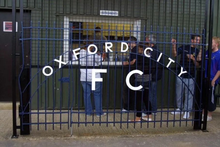 Hàng rào sân vận động Oxford City FC, một khung cảnh quen thuộc nơi biên giới cỏ xanh và khán đài im lìm
