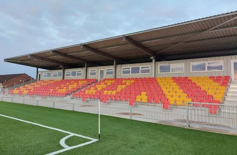 Khán đài có mái che với hàng ghế đỏ ở sân Meadow Park, nơi người hâm mộ Gloucester City AFC tìm về.