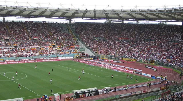 Không khí cuồng nhiệt trận đấu AS Roma tại Stadio Olimpico, tiếng reo hò vang vọng dưới vòm trời lịch sử Rome.