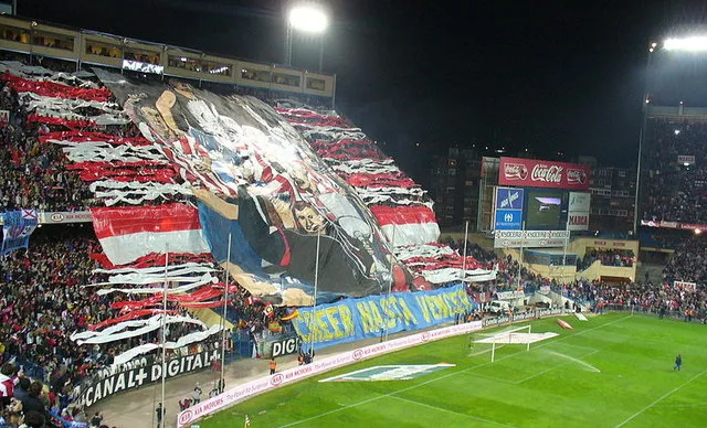 Khung cảnh trận Derby Madrid giữa Atletico và Real Madrid tại sân Vicente Calderón, khán đài tràn ngập sắc màu và đam mê.