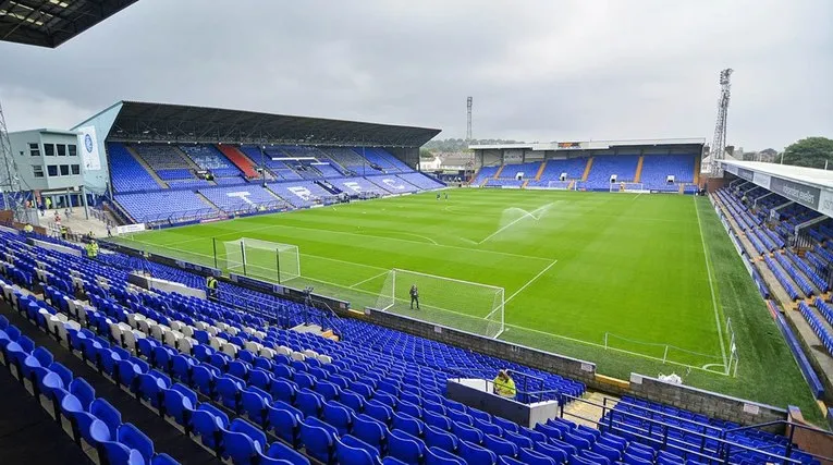 Mặt sân Prenton Park nhìn từ trên cao, cỏ xanh mướt và khán đài tĩnh lặng