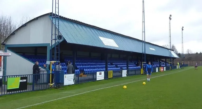 Những hàng ghế trống lặng lẽ tại Longmead Stadium, chờ đợi khoảnh khắc bóng lăn