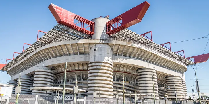 Toàn cảnh mặt ngoài sân San Siro trong ánh hoàng hôn, khoảnh khắc tĩnh lặng trước khi những cảm xúc bóng đá bùng nổ.
