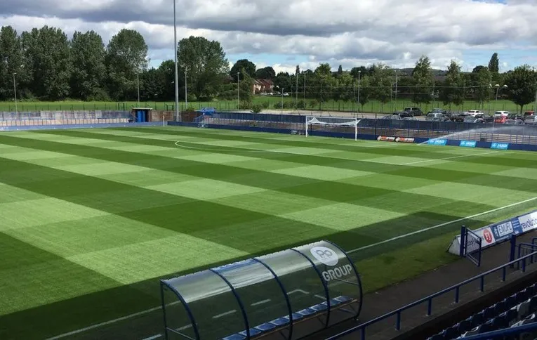 Toàn cảnh sân Tameside Ashton nhìn từ khán đài chính, góc nhìn yên bình của trận đấu Curzon Ashton