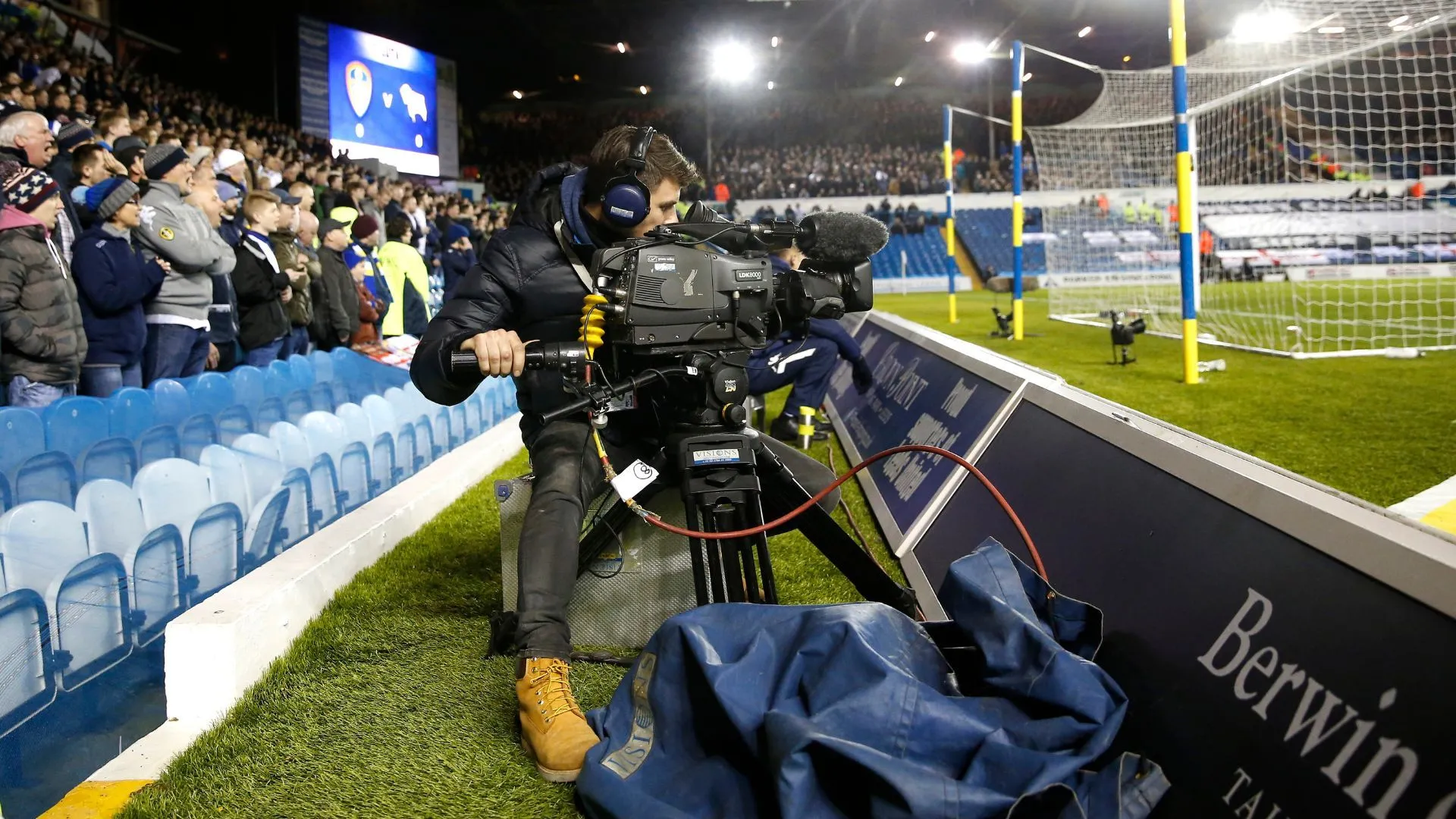 Camera truyền hình đang ghi lại cảnh quay một trận đấu bóng đá