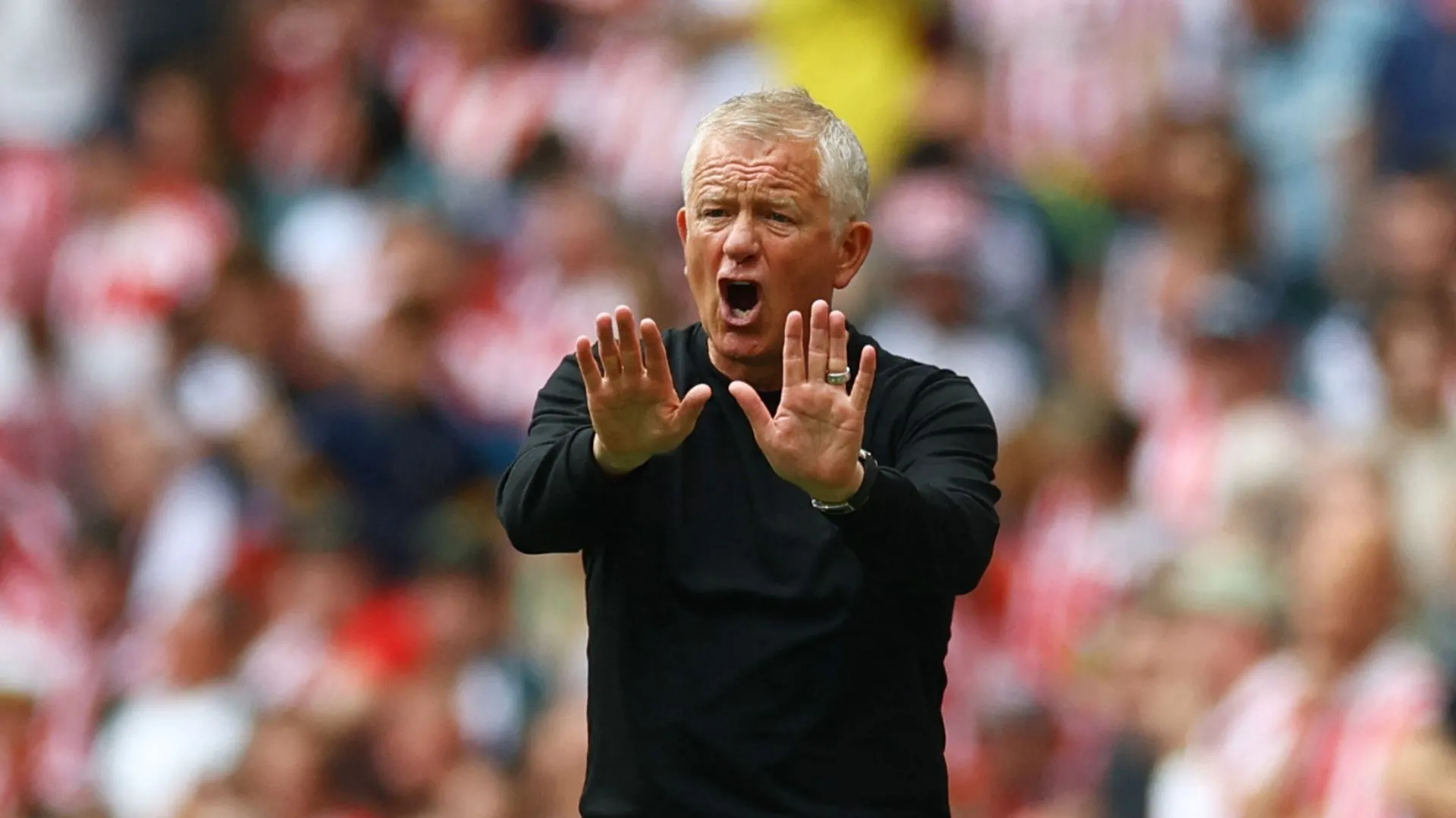 HLV Chris Wilder của Sheffield United đứng lặng lẽ bên đường pitch, gương mặt đầy suy tư sau trận đấu gây tranh cãi.